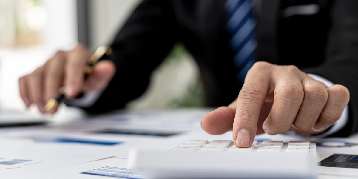 businessman-using-calculator-to-calculate-numbers-on-company-s-financial-documents-he-is-analyzing-historical-financial-data-to-plan-how-to-grow-the-company-financial-concept 1